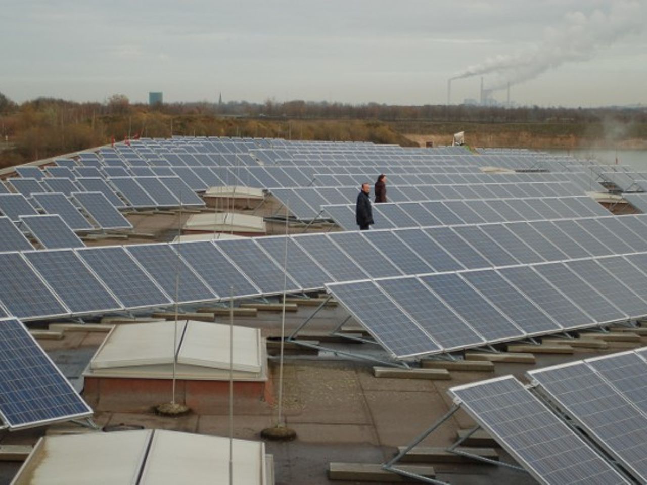 PV-Anlage auf einem Dach, auf dem Dach stehen zwei Menschen